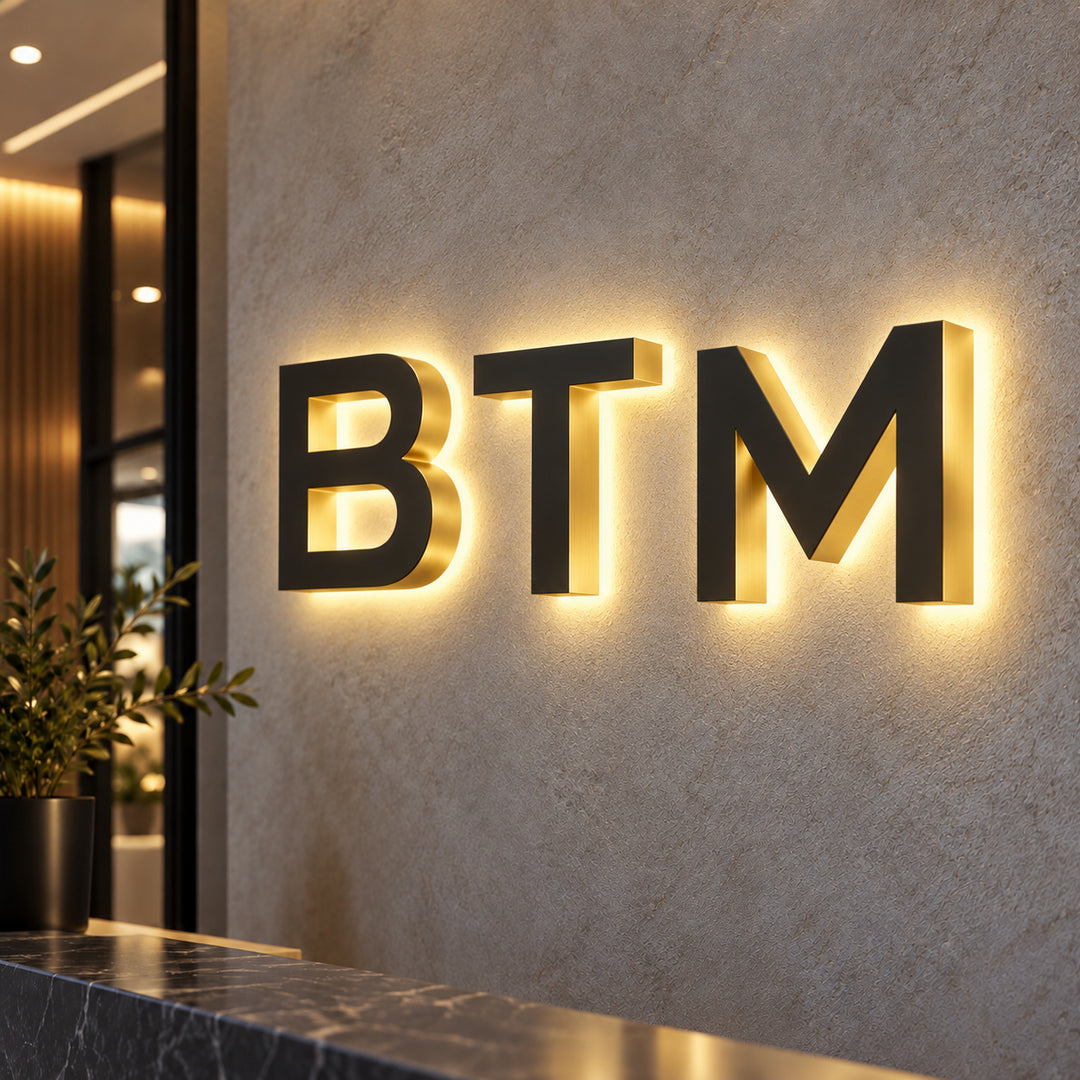 BTM metal channel letters with opaque, unlit metal fronts and warm rear lighting that creates a halo on the wall.