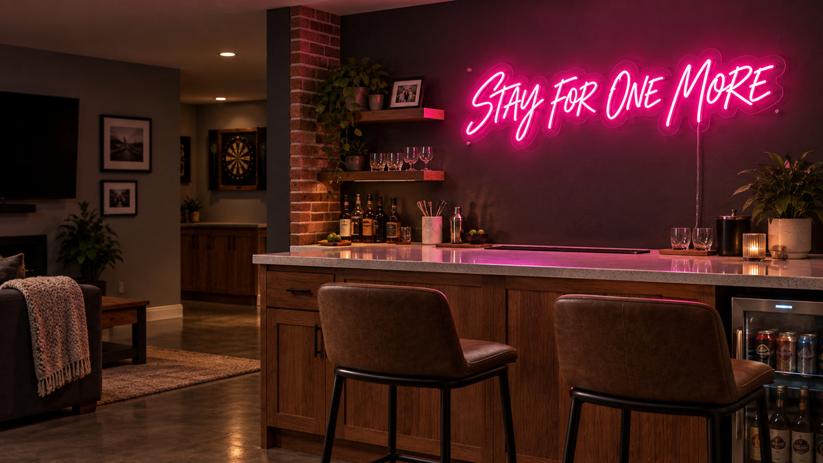 Illustrative home bar with a pink Stay for One More LED neon sign above a wood counter.